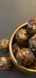 Nutty Coffee Bites β healthy sugar-free energy balls made with almonds, cashews, dates, anjeer, and seeds, served in a brass bowl.